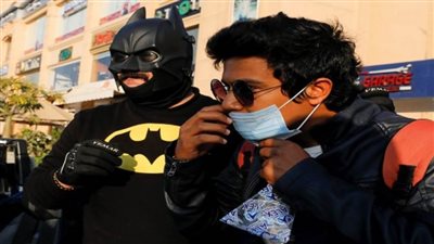 بالصور.. في مهمة ضد «كورونا».. «بات مان» مصر يوزع الكمامات على المارة